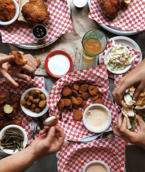 a group of people sitting at a table with a plate of food