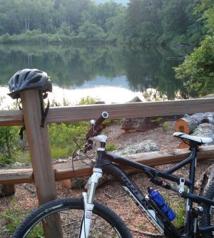 a bicycle parked on the side of a river