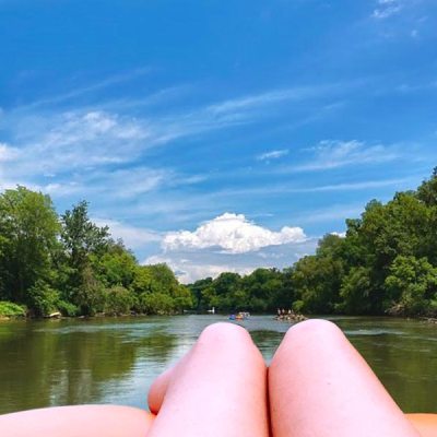a boat floating along a river next to a body of water