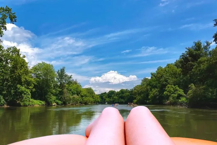 a boat floating along a river next to a body of water