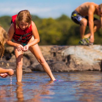 a group of young men sitting next to a body of water