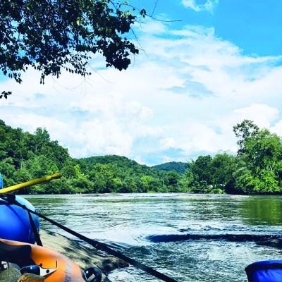 a boat floating along a river next to a body of water